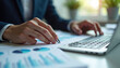 © stockphoto02 - Businessman analyzing financial data on laptop  highlighting key figures.