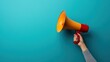 © StudioPixel - Hand holding a megaphone emerging from a phone screen with space for advertisement