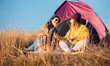 © Zoran Zeremski - Two women camping at top of the hill sitting in front of the tent resting after hiking.