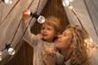 © RooM The Agency - Mother and daughter in a play tent looking at and playing with light bulbs
