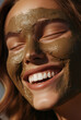 © coffeeflavour - Close-up of the face of a beautiful, smiling young woman sprinkled with mud or clay for an aesthetic treatment.