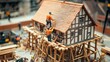 © Valentyna Prudnikova - Miniature construction scene depicting workers building a detailed model house with timber framing and scaffolding, showcasing intricate craftsmanship and architectural design.