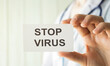 © Pawel - Stop virus text on card and hands holding it. Healthcare or prevention concept.