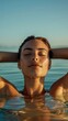 © LukaszDesign - Attractive woman swimming in the ocean, savoring a summer getaway and a leisurely weekend
