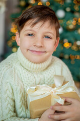 boy in a white sweater with a gift