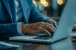 © S photographer - Close-up of hands typing on a laptop in a stylish office environment.