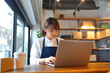 © Suthiporn - Young Asian Woman Using Laptop for E-commerce Startup at Cozy Workspace Generative AI Technology