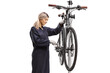 © Ljupco Smokovski - Female bike mechanic fixing a bicycle on a stand
