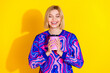 © deagreez - Photo portrait of pretty young girl smell aroma coffee hold paper cup wear trendy colorful blue outfit isolated on yellow color background