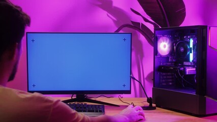 Computer with chroma key green screen on monitor. Gamer man playing in popular video games. Programmer or hacker coding a code and working in networks, cyberspace. Digital software, mobile app