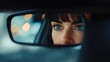 © BlockBrushstrokes - Woman driver focusing in rear view mirror reflecting bright bokeh lights in a car interior showcasing attentive driving and safety awareness