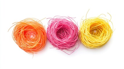 Colorful spaghetti nests in vibrant orange pink and yellow arranged on a clean white background ideal for food and culinary themed projects