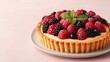 © kwangze - A delicious fruit tart topped with fresh raspberries, blackberries, and a sprig of mint, sitting on a light-colored plate against a soft background.
