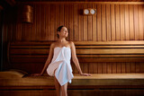 Relaxed woman in the sauna at wellness center.