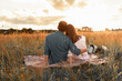 © kieferpix - Romantic date. Couple is enjoying picnic time at sunset talking, hugging, enjoying time in nature together