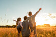 © kieferpix - Father and his children walking in a field at sunset enjoying time together in nature, family future, single parent concept