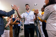 © Mediteraneo - Young businessman receiving prize cup, proud colleagues applauding for him and cheering.