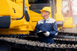 © Parilov - Worker with tablet inspects bulldozer at coal and sand quarry, concept industry truck maintenance