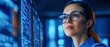 © NovaVision - Female System Engineer in Blue Shirt and Glasses Analyzing Data on Digital Screen