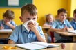 © Aksana - Young child sneezing in classroom setting with classmates focused on learning