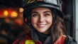 © KarpenArt Studio - Confident female firefighter smiles while wearing protective gear inside fire station garage, ready for duty