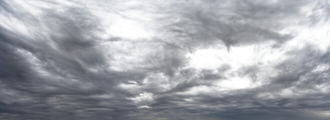 Wall Mural - panorama of gray cloud filled rain sky with local transparent areas