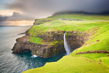 Wall Mural - Múlafossur waterfall and Gásadalur village on Vágar Island in the wild Faroe Islands