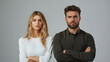 © Michael - Studio portrait of a serious young couple standing with crossed arms against a grey background, conveying confidence, unity, and subtle tension