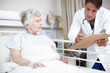 © peopleimages.com - Doctor, clipboard and elderly patient in hospital bed for healthcare results, surgery update and bad news. Senior woman, nurse and health support for diagnosis, illness progress and explaining notes