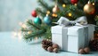 © Maryna - Elegant gift placed near Christmas tree. White present wrapped with grey ribbon. Decorated with colorful ornaments, twinkling lights. Festive atmosphere. Christmas season. Cozy scene. Holiday gifts.