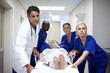 © peopleimages.com - Healthcare, medical team or patient in hospital for emergency, intensive care or woman in distress. Doctors, people or client on stretcher bed for elderly help, allergic reaction or ready for surgery