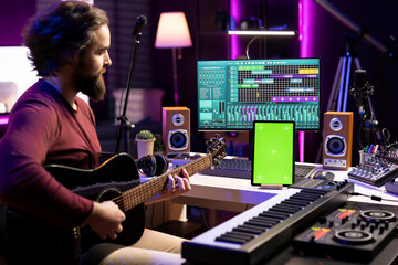 Aufkleber - Composer playing acoustic guitar after following online tutorial, learning new strings accords in his home studio. Music producer learning to p lay a new melody on instrument, greenscreen layout.