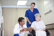 © peopleimages.com - Healthcare, explaining and senior woman with doctor, hospital and conversation for diagnosis and retirement. Clinic, medical professional and talking with person with disability, wheelchair and nurse