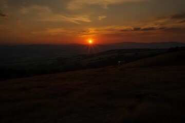 Poster - Sunset over rolling hills and fields.