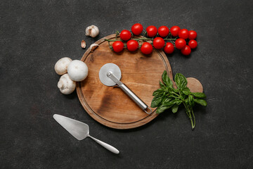 Canvas Print - Composition with stainless steel pizza cutter, spatula and fresh vegetables on dark background