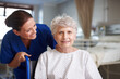 © peopleimages.com - Confident, caregiver and senior woman in hospital, smile and healthcare for recovery, assisted living and joy. Sick, retirement and elderly person with disability, nurse or help for patient in clinic