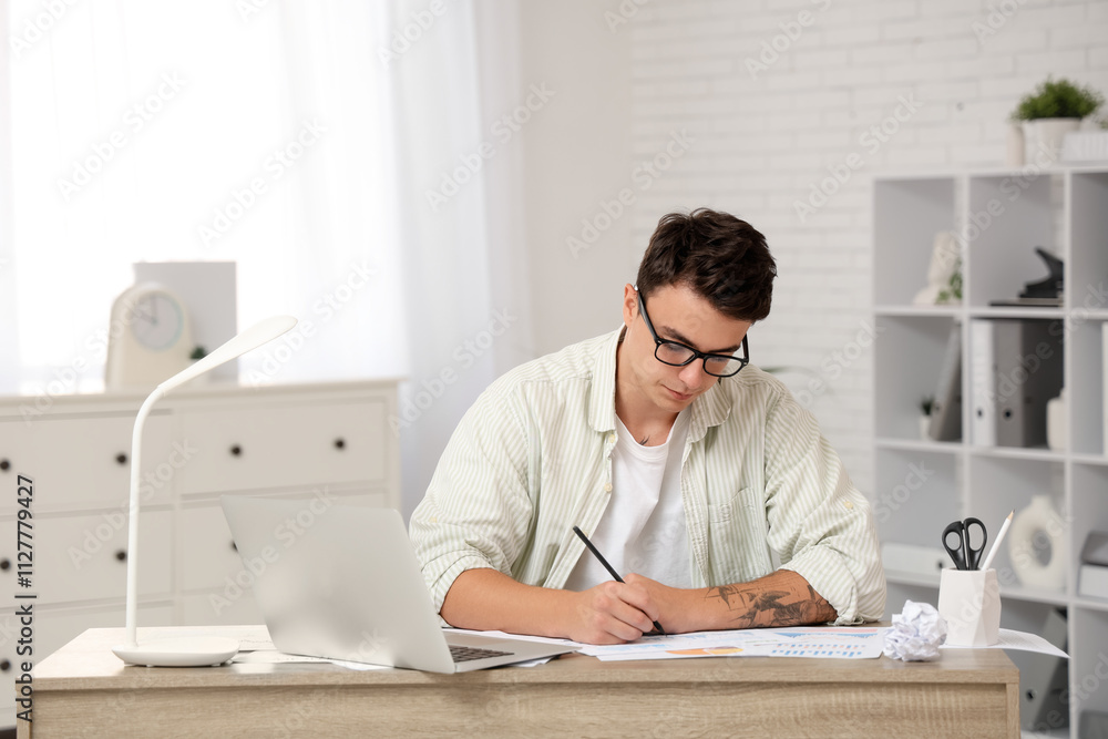 Male economist working with diagrams at table in office