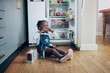 © peopleimages.com - Portrait, girl and child by fridge for snack, juice or drinking beverage in house alone on floor. Kitchen, naughty and thirsty African kid in home for mischief or lunch in refrigerator with straw