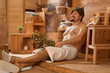 © Pixel-Shot - Handsome man with whisk relaxing in sauna