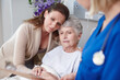 © peopleimages.com - Elderly mom, daughter and hug in clinic for support, love and medical health with family or women. Thinking, sad people or embrace for senior care, comfort or bad news for sick patient in hospital