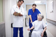 © peopleimages.com - Healthcare, checkup and senior woman with doctor, hospital and explaining of diagnosis and retirement. Clinic, medical professional and conversation with person with disability, wheelchair and nurse