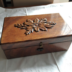 Exquisite wooden treasure box with intricate leaf carving on top, perfect for storing memories and valuables, photography of still life concept.