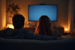 © Nyetock - Back view of a couple watching tv in a couch at home. Blank screen view