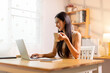 © David - Drinking coffee, asian woman working on laptop at home office desk, copy space