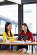 © David - Shot of two businessasianwomen working together on digital tablet. Creative female executives meeting in an office using tablet pc and smiling.