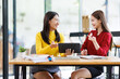 © David - Shot of two businessasianwomen working together on digital tablet. Creative female executives meeting in an office using tablet pc and smiling.