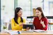 © David - Shot of two businessasianwomen working together on digital tablet. Creative female executives meeting in an office using tablet pc and smiling.
