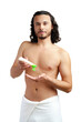 © fotofabrika - A young man applying skincare cream on his face with a focused expression, demonstrating personal grooming at home