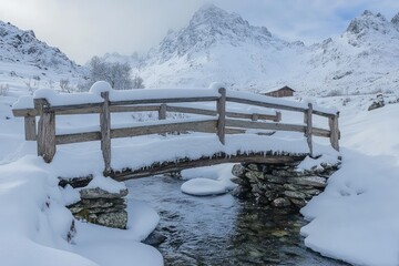 Wooden bridge crossing a stream in a snowy mountain landscape