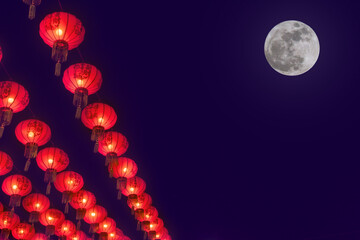 Group of traditional red paper Chinese lanterns in Chinatown at twilight and full moon. Background for Chinese New Year greeting theme.